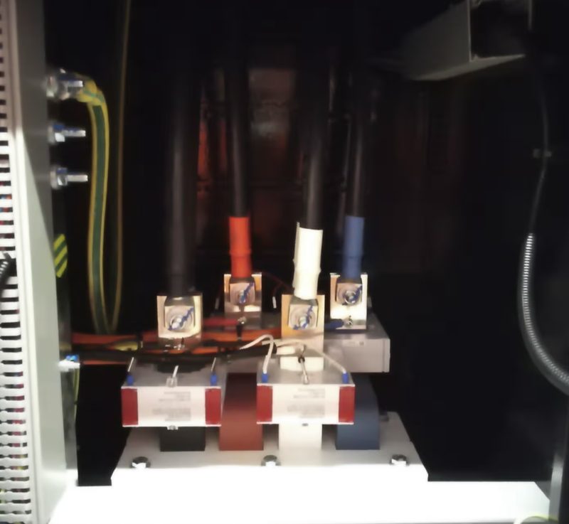 Cable terminations with red, white and blue phase markings inside an open data centre switchboard